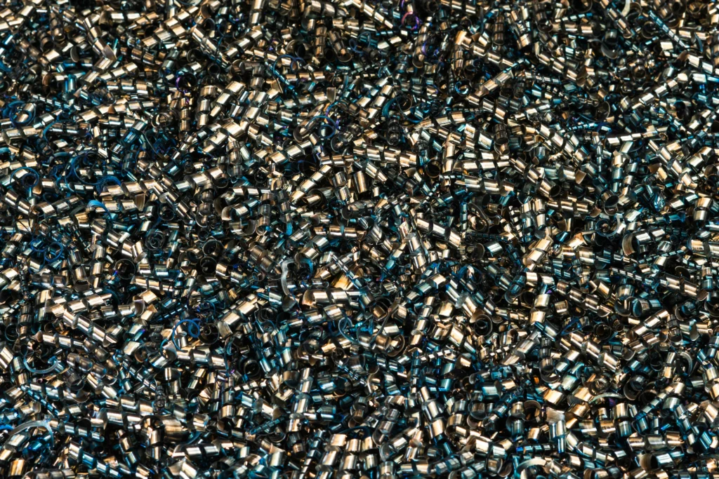 Gęsta masa metalowych wiórów po obróbce CNC (Cooling and chip removal, CNC-Bearbeitung), związana z procesem Chłodzenie i odprowadzanie wiórów w produkcji.