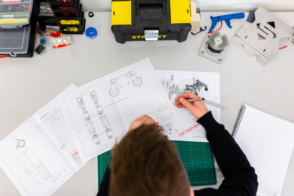 Ingenieur arbeitet mit technischer Dokumentation im Reverse Engineering vor der Vorbereitung eines Bauteils für die CNC-Bearbeitung.
